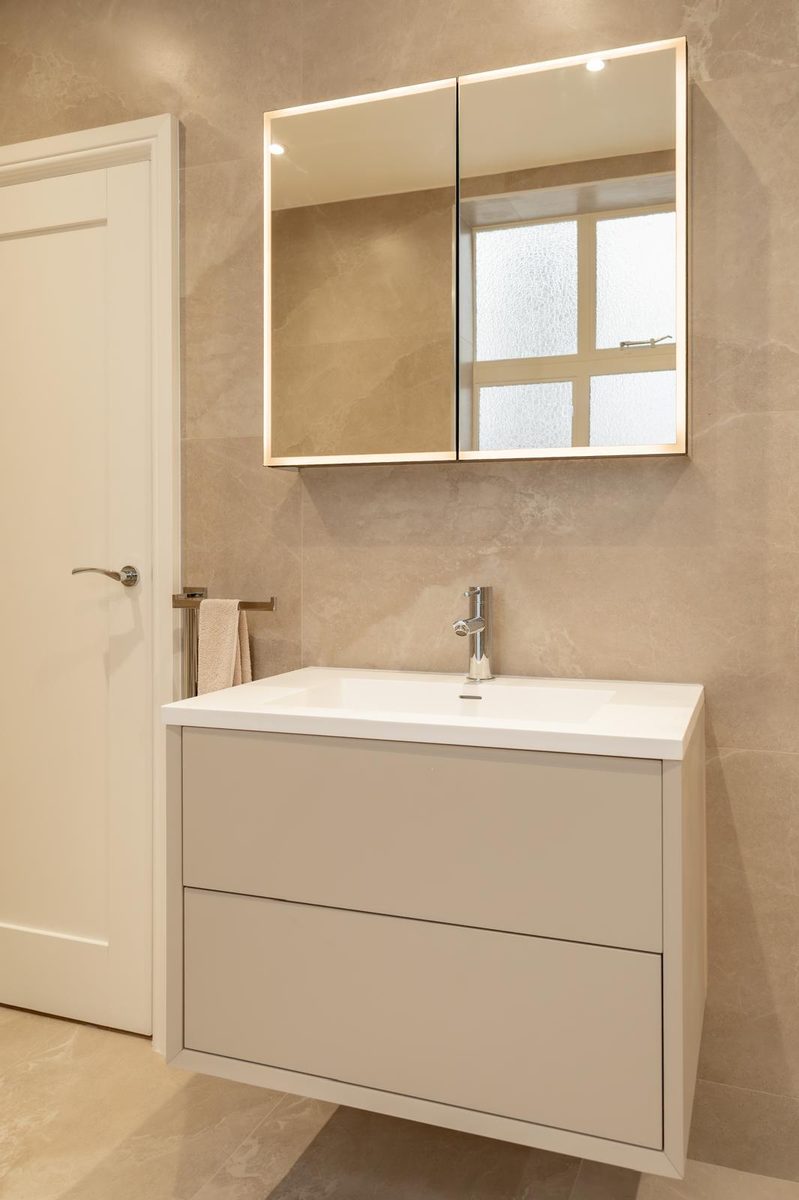 Vanity with LED mirror cabinet and marble walls