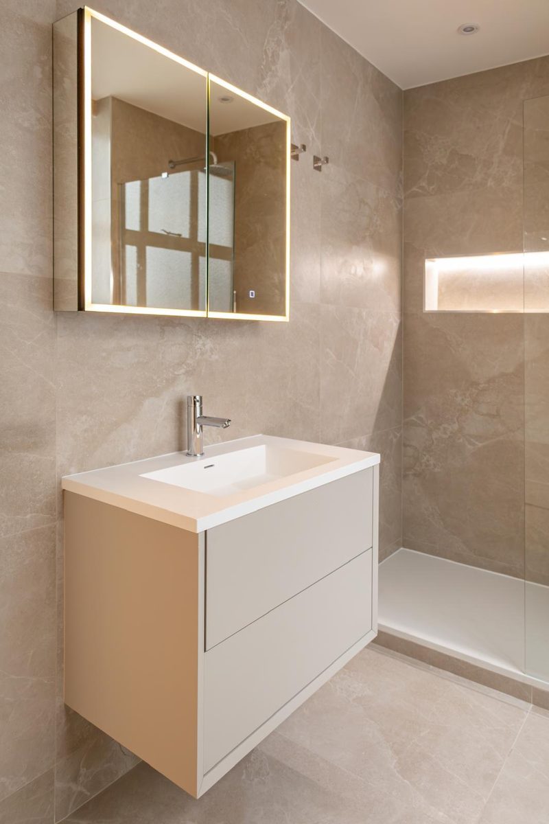 Vanity with gold-framed mirror and shower tray