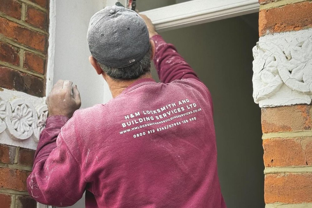 H&M Building Services engineer sealing a sash window frame on site